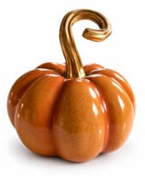 Glossy orange ceramic pumpkin with speckled glaze and a curled gold-coloured stem on white