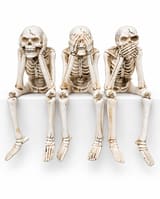 Set of three aged bone-coloured skeleton shelf sitters covering ears, eyes and mouth, with dangling legs