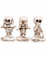 Three cross-legged skeleton figurines in hear, see and speak no evil poses