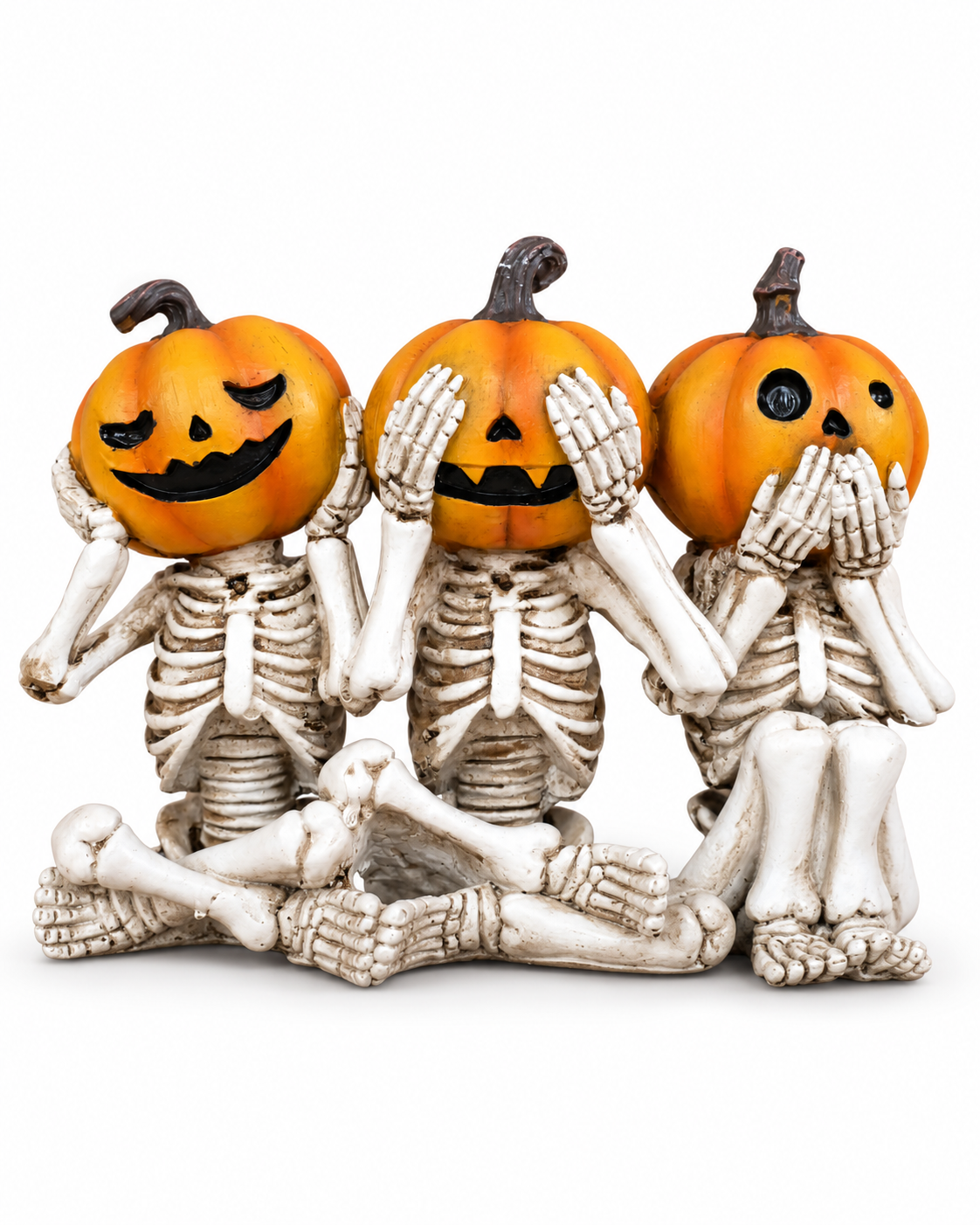 Three seated pumpkin-headed skeletons depicting hear, see and speak no evil
