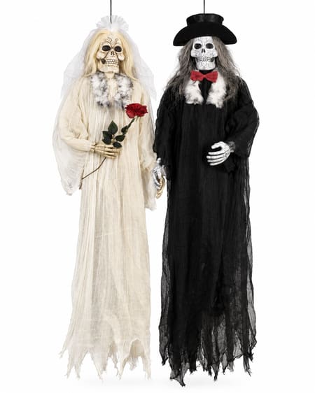 Skeleton bride and groom hanging Halloween decorations in wedding costumes