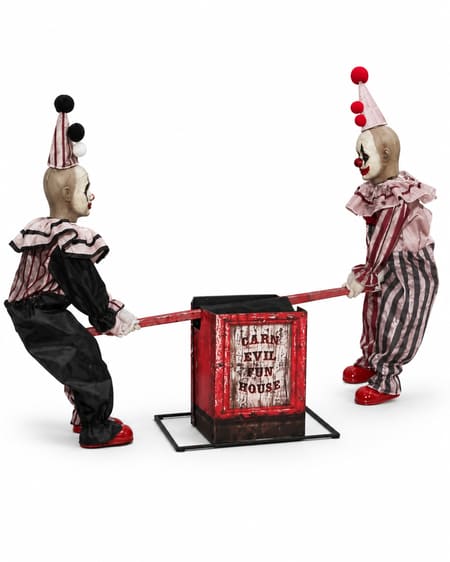 Two creepy clown figures seated on an animated Halloween seesaw