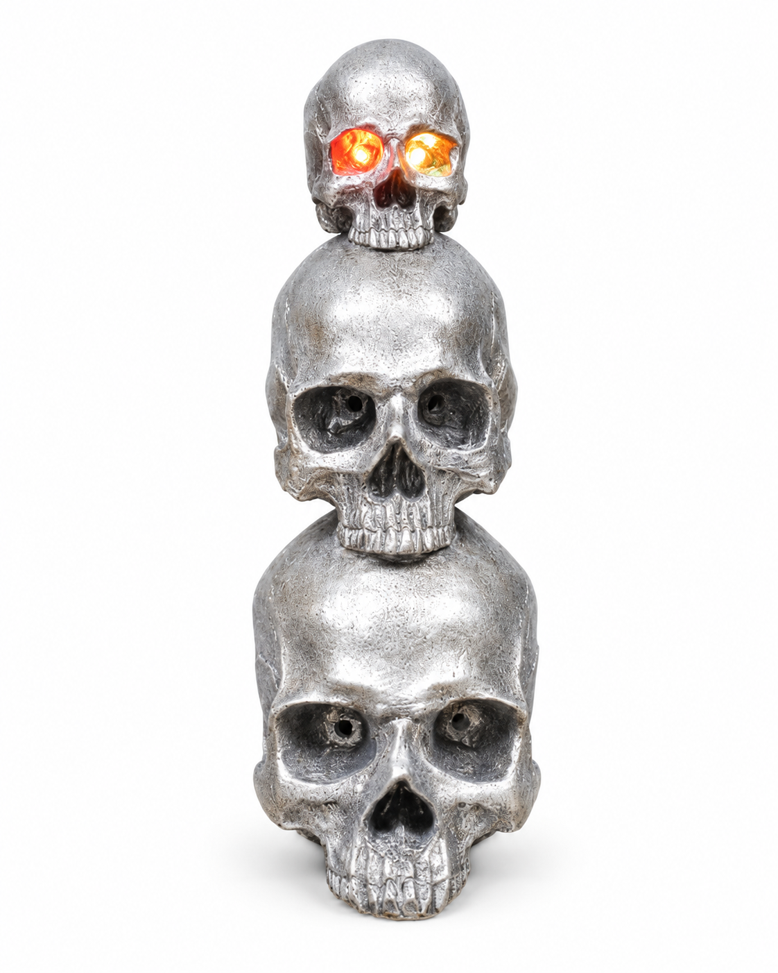 Three textured silver skulls stacked vertically, with glowing orange and yellow eyes on the smallest top skull