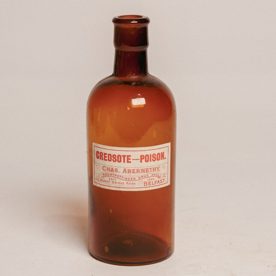 A brown bottle with a label that says "creosote - poison"