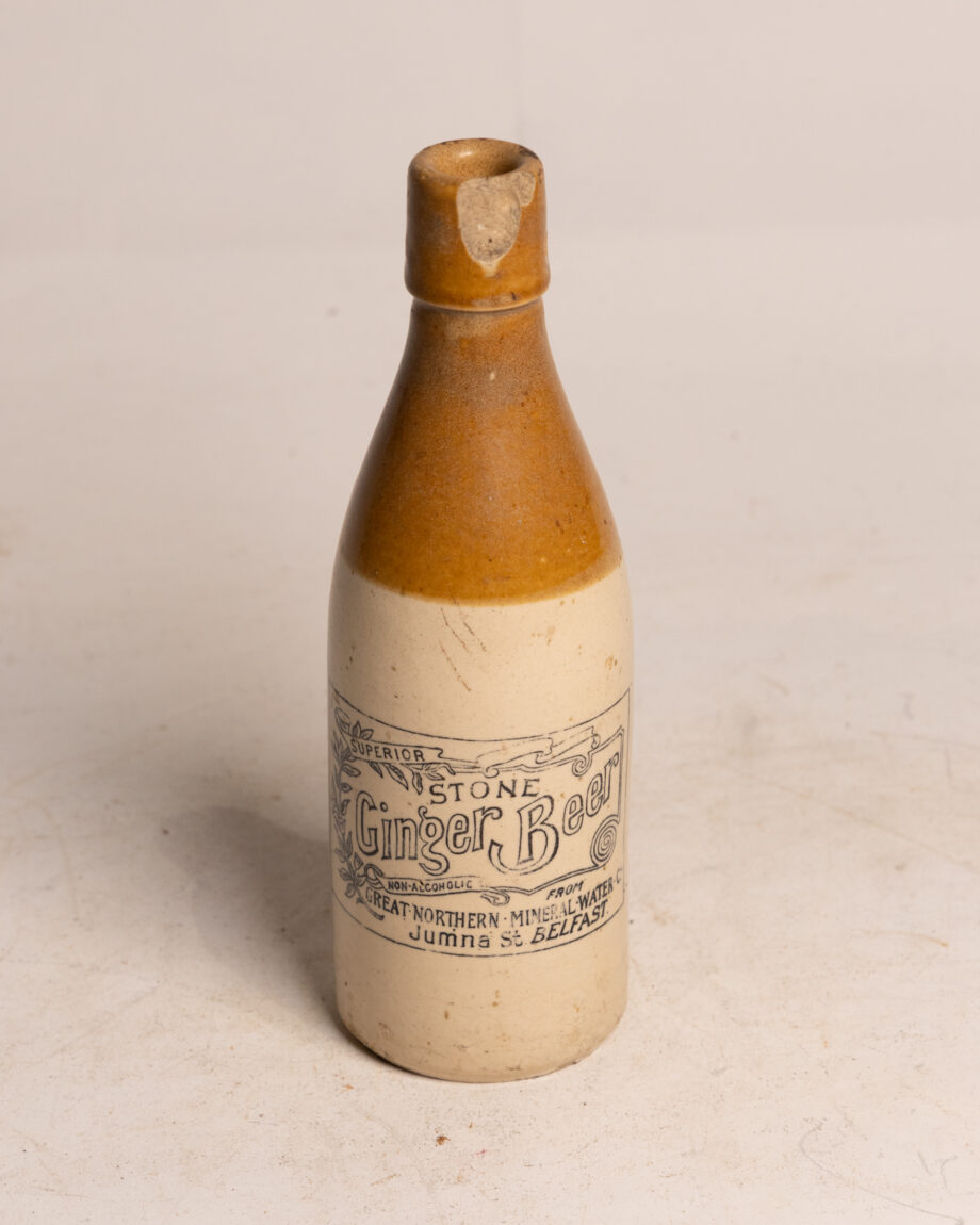 A stoneware bottle with a dark brown top for belfast ginger beer