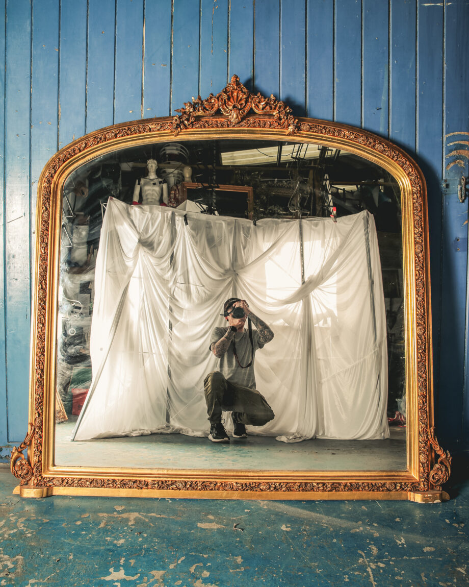 A large mirror with a rounded top and a gold frame