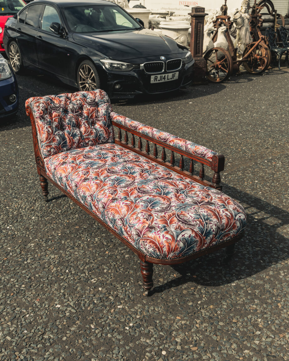 A chaise lounge made with intricate fabric. 