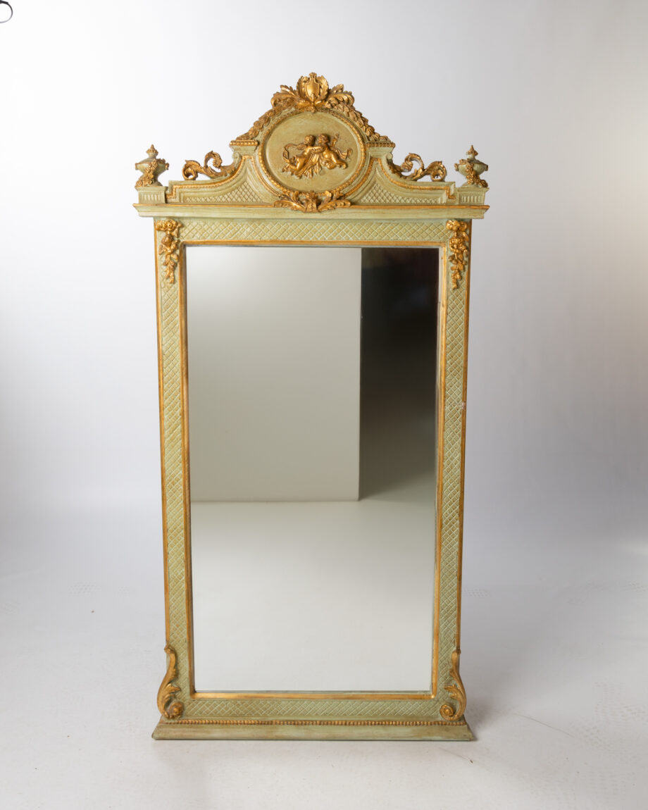 A mirror with a green frame and gold edging