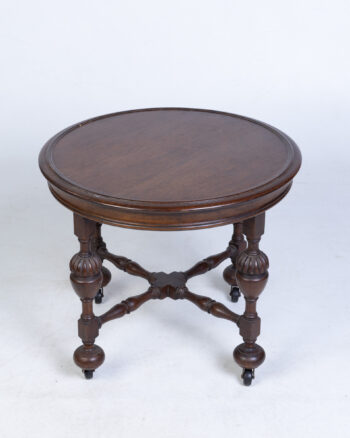 Vintage round wood side table with rolling castors and decorative legs.