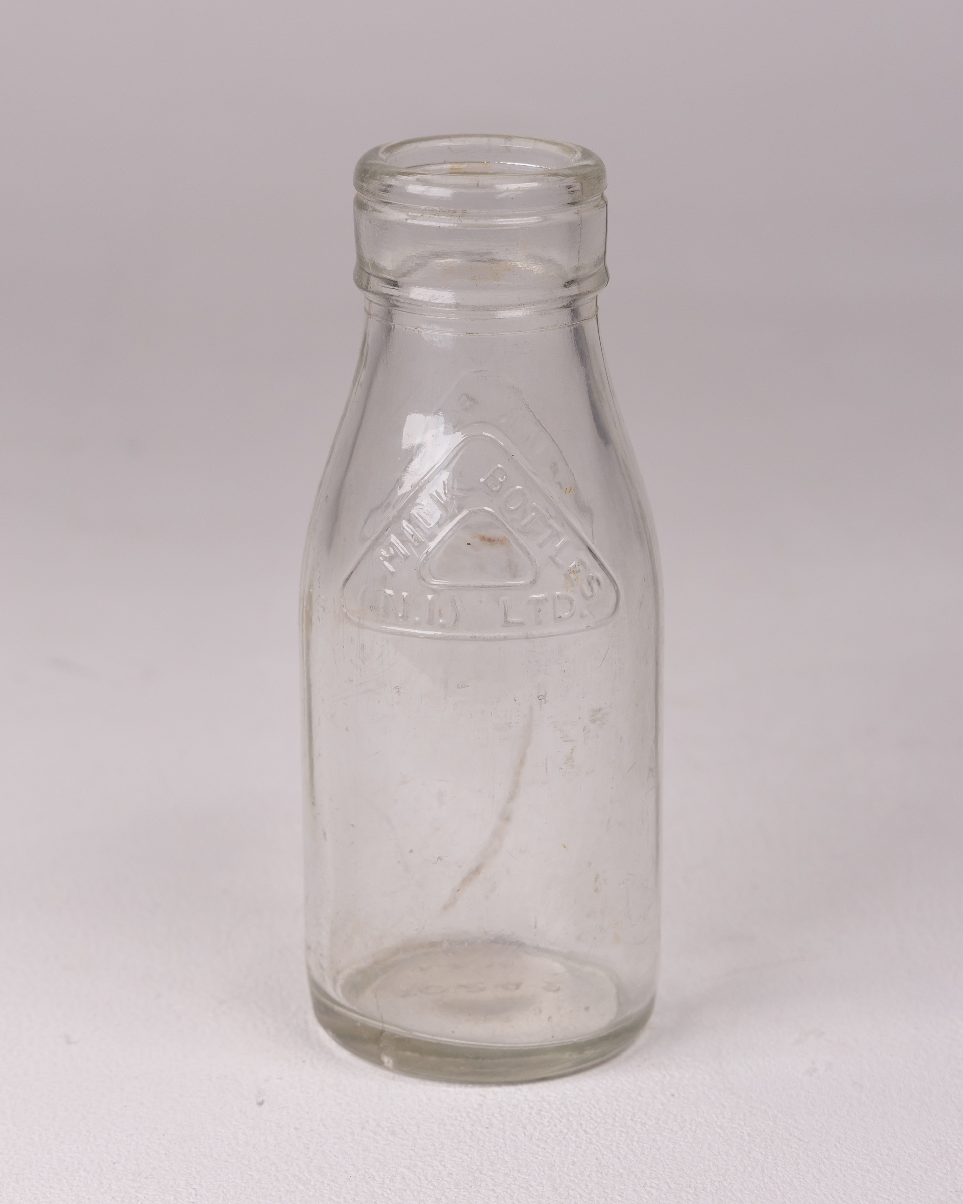 Vintage Clear Glass Milk Bottle with ‘MILK BOTTLES (N.I.) LTD’ Embossed Logo