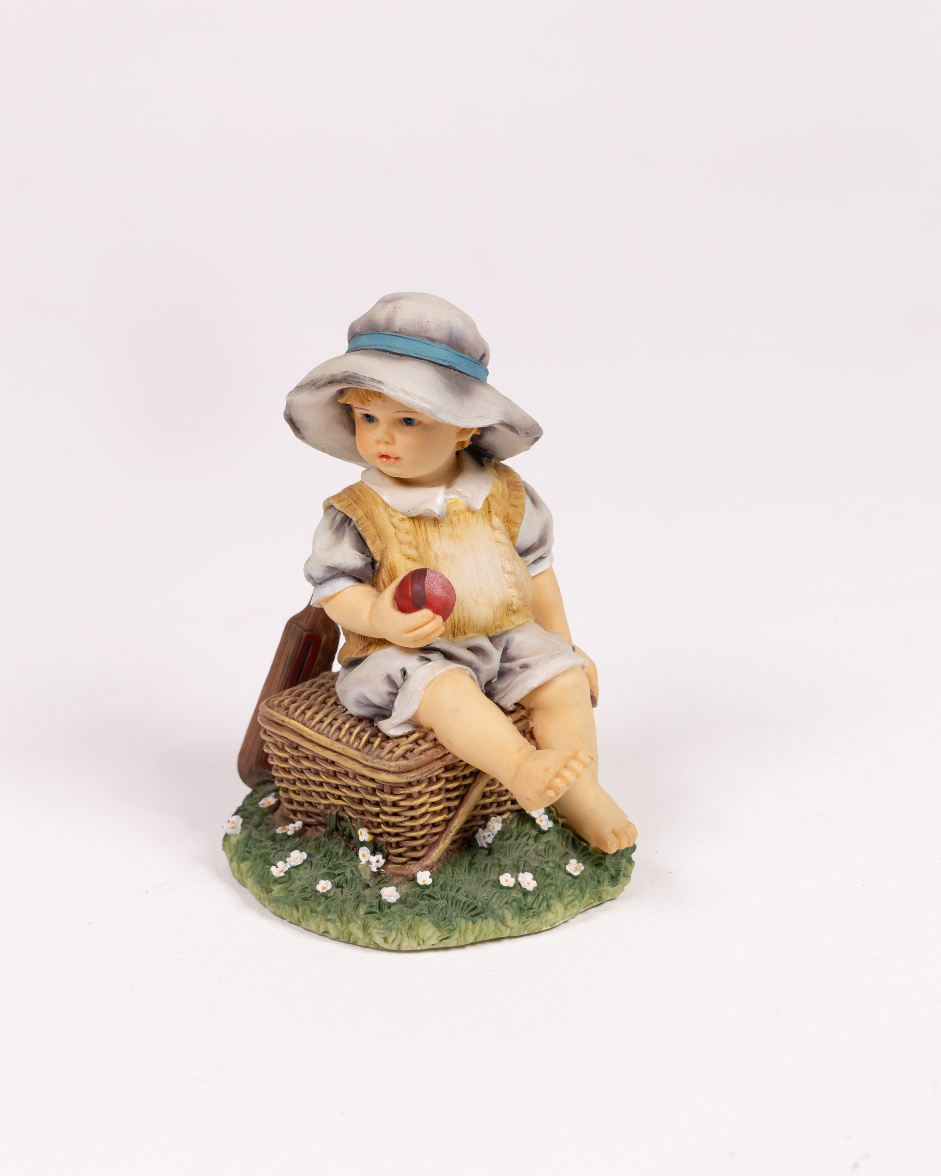 Figurine of Boy on Wicker Basket with Apple