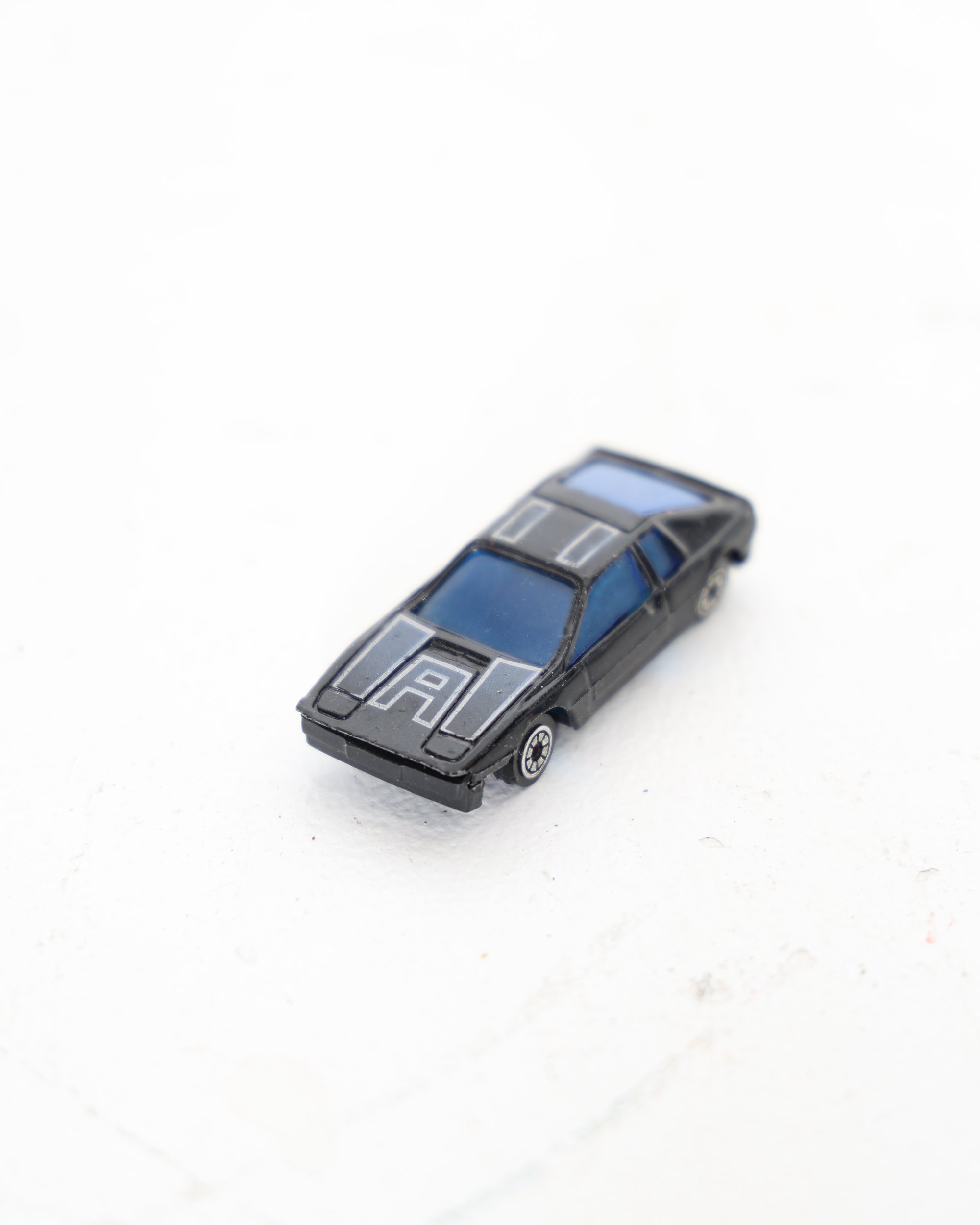 Miniature Black Diecast Toy Car with Blue Windows