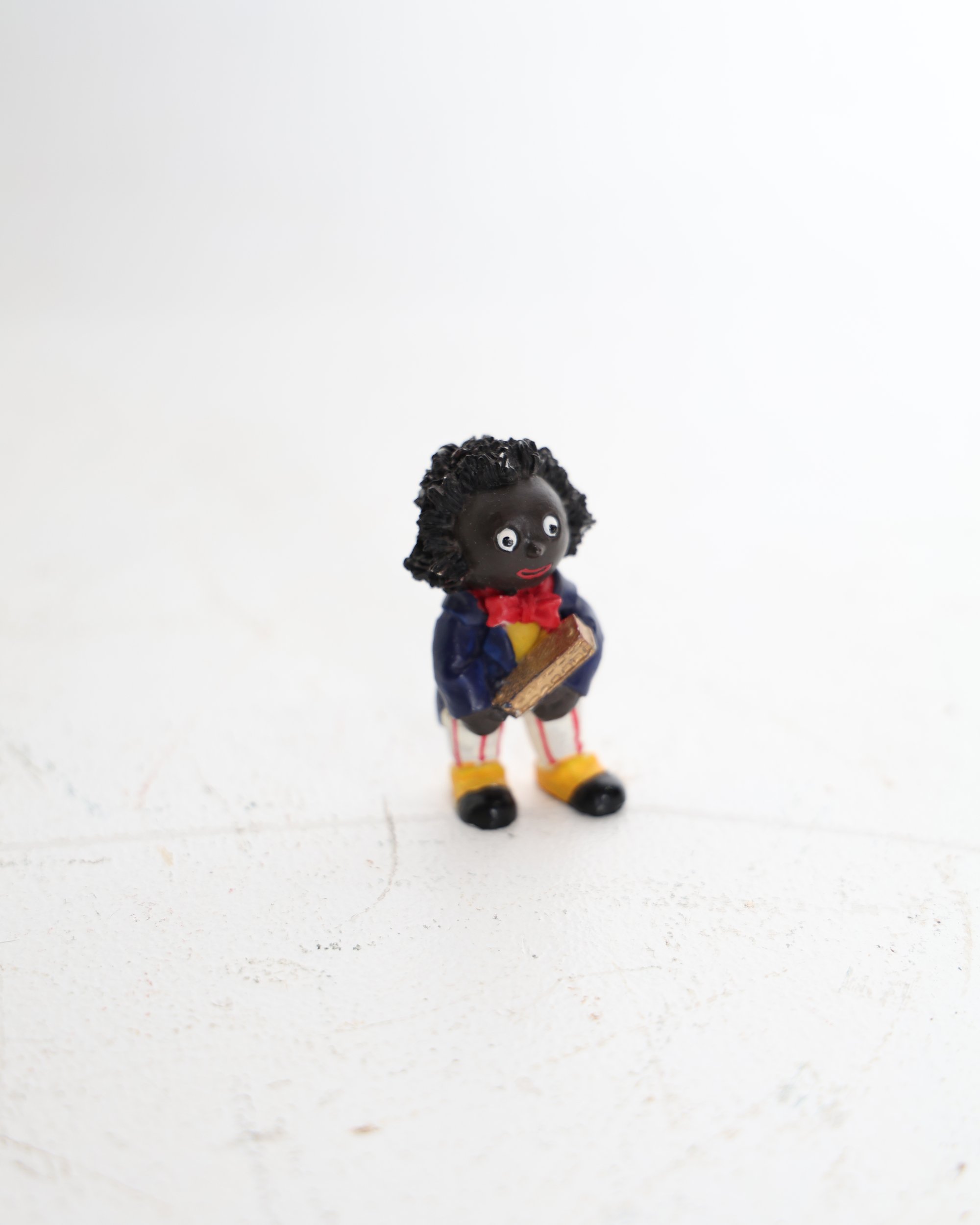 Small Golly Figurine Holding a Golden Book