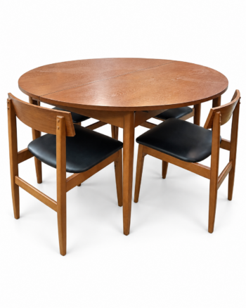 Round wooden dining table with four chairs on a white background